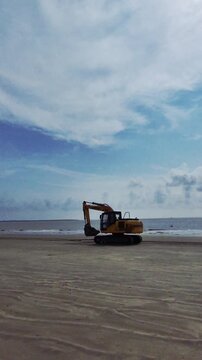 Excavator at a beach to protect sea wall.