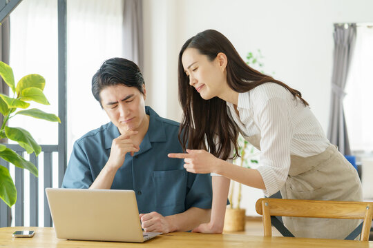 リビングで指をさして喧嘩をする若い日本人カップル
