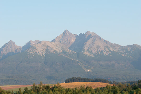 lomnicky stit peak high tatras mountain range clear blue sky green forest golden fields carpathians slovakia panoramic view concept of travel, nature, tourism