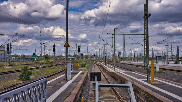 Weitl&auml;ufige Gleisanlagen, Schienen und Oberleitungsmasten an Bahnsteigen mit Prellb&ouml;cken unter einem dramatischen Wolkenhimmel am Hauptbahnhof, Leipzig, Sachsen, Deutschland