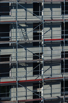 View of metal scaffolding covering the facade of a modern building under construction in Vilnius, Vilnius County, Lithuania.