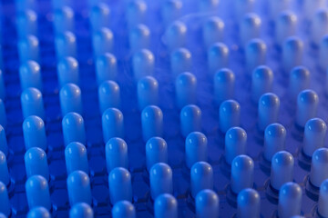 Obraz premium Blue gelatinous capsule with liquid nitrogen on plastic blister tray conveyor, Pharmaceutical production factory