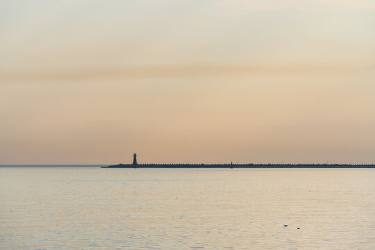 View of the lighthouse on the breakwater at sunset in the Baltic Sea in Gdansk, Pomeranian Voivodeship, Poland.