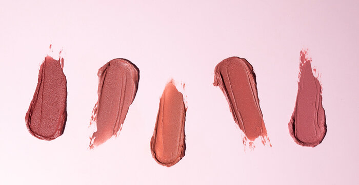 Five lipstick swatches on pink background