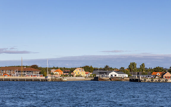 View of the harbor and colorful waterfront buildings under a clear blue sky in Fur, Jutland, Denmark.