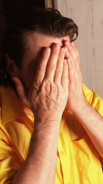The man is sincerely remorseful. He is upset and covers his face with his hands out of shame.
