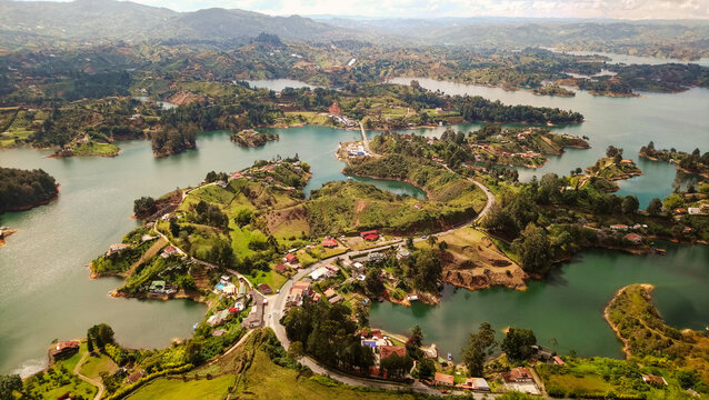View of El Penon de Guatape overlooking the winding reservoir, lush green islands, and surrounding hills in Guatape, Antioquia, Colombia.