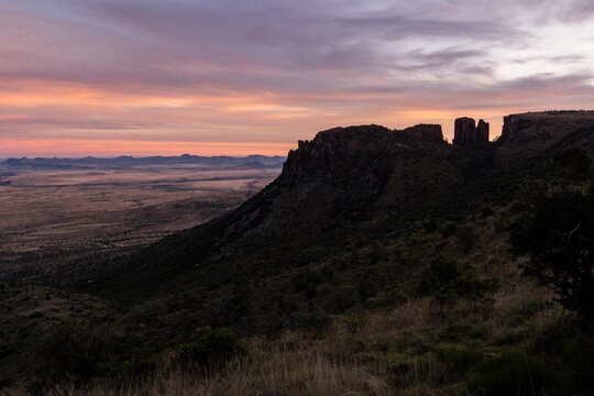 View of the rugged mountain landscape at sunset with a vast plain stretching into the distance in South Africa.
