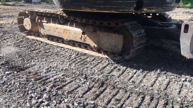 Backhoe excavating soil at a construction site with laborer operating heavy machinery safely.