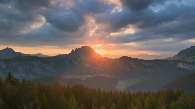 Golden sunset over pine forest mountains during dramatic cloudy sky cinematic aerial flyover