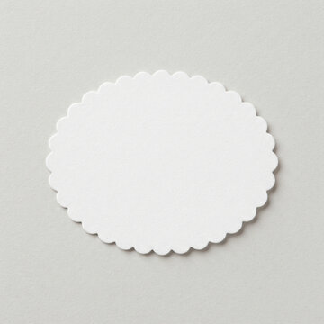 White scalloped oval paper label isolated. Stationery mockup and craft decoration.
