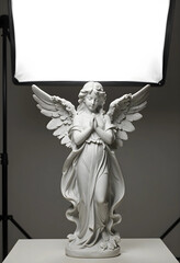 Fototapeta premium Spirituality and peace marble angel statue with praying hands for religious memorial funeral service and divine grace in studio lighting