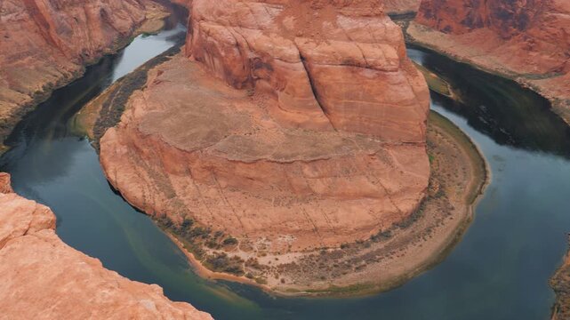 Majestic view slowly revealing the iconic horseshoe bend, a spectacular meander of the colorado river winding through the dramatic red rock canyon landscape of glen canyon near page, arizona