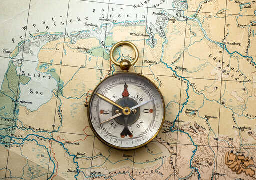 Magnetic compass on old world geology map. Travel, geography, navigation, tourism and exploration concept background.