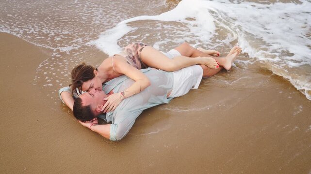 Loving couple embracing peacefully in shallow sea water, enjoying closeness and affection by the beach, representing emotional wellbeing, relaxation, happiness, trust and healthy romantic connection.