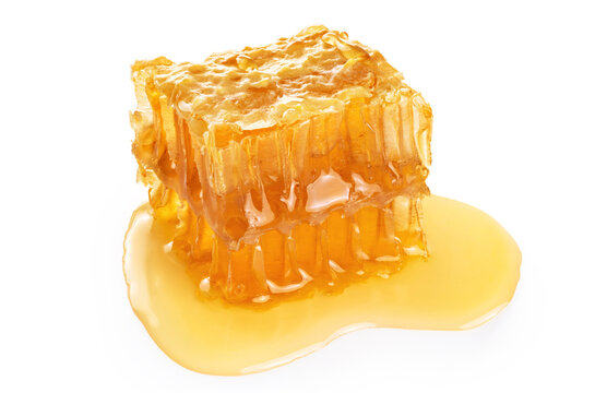 Piece of wax honeycomb filled with honey, isolated on white background.