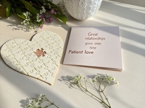 Heart shaped puzzle with inspiring quote card and flowers