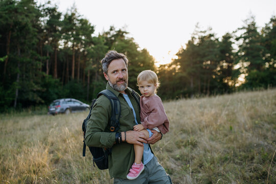 Father and children enjoying outdoor family vacation at campsite.