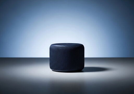 Dark blue smart speaker on a surface with gradient lighting and shadow