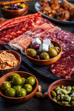 Assortment of cured meats and antipasti served on a rustic wooden board