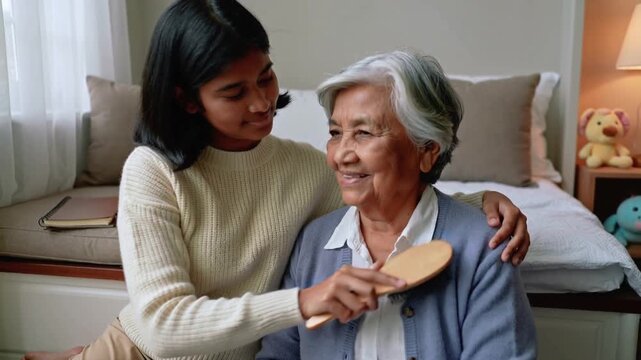 Brushing adult in cream sweater, reaching wooden brush, steadying senior's head in bedroom, caring