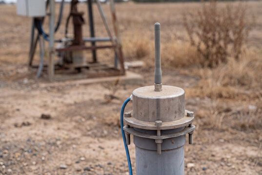Groundwater monitoring telemetry unit on a wellhead in a rural field