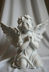 Fototapeta premium Spirituality and faith concept small angel statue with praying hands for religious peace hope and divine protection in a serene memorial setting