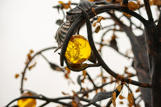 Decorative metal tree with amber leaves and fruits, installed on the observation deck of the Primorsky quarry of the Kaliningrad amber plant in the village of Yantarny