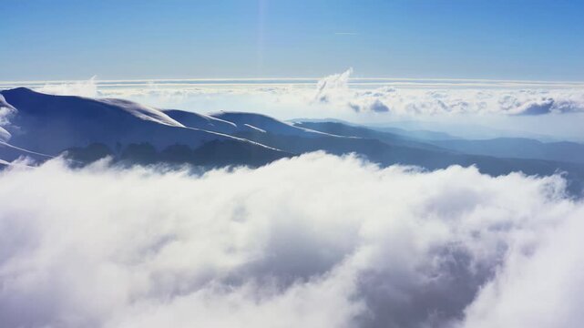 An extraordinary mountain valley covered with fluffy clouds at winter sunset
