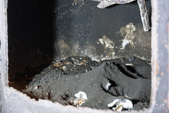 Heavy soot buildup inside wood burning stove after chimney cleaning
