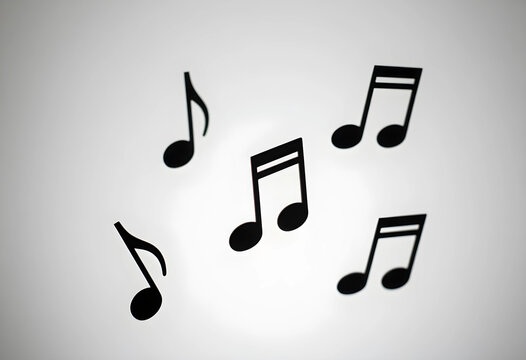 Music and creativity concept, black musical notes floating on a clean white background for artistic design, entertainment and melody composition theme