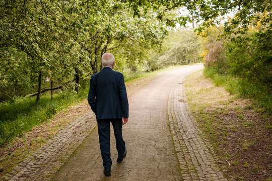 Senior man walking path, contemplating future journey