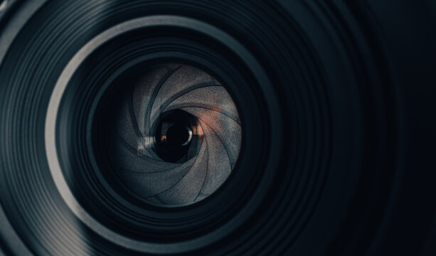 Close Up of Camera Lens Aperture Blades and Glass Element,Macro,An extreme macro front view looking directly into the aperture mechanism of a camera lens. The photograph highlights the curved.