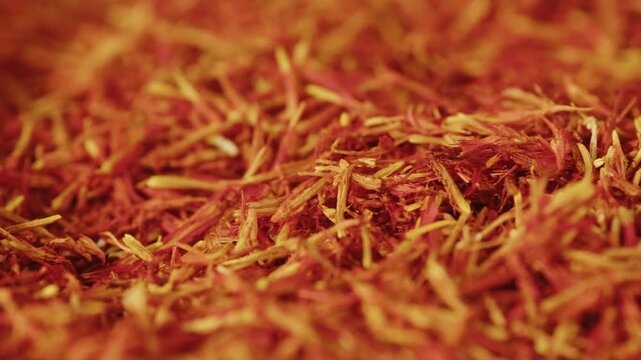 Saffron threads being tested and inspected by a Turkish man at a spice market stall in a supermarket, premium red spice from Turkey, Iran and India