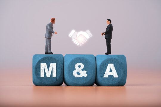 Mergers and acquisitions concept with businesspeople and handshake symbol on M and A blocks represent corporate merger, acquisition partnership, negotiation deal and business integration strategy.
