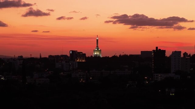 Illuminated Restoration Monument Rising Above Santiago Skyline During Orange Sunset