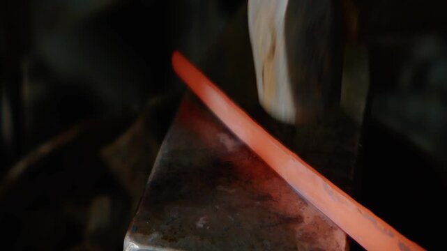 Blacksmith Forging Glowing Hot Metal Bar on Anvil