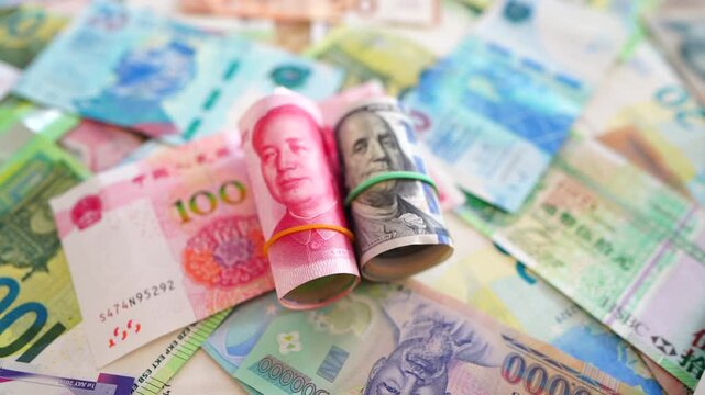 Chinese yuan, US dollars among various currencies background. Banknotes different countries denominations. Chinese yuan, US dollars and foreign currencies. World's reserve currency in global trade.