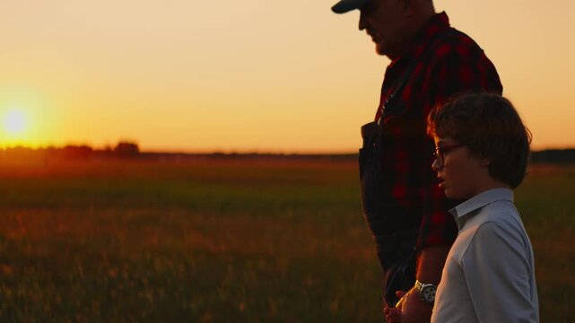 Grandfather and grandson walking together through a peaceful rural field at sunset, sharing a quiet intergenerational moment in the warm evening light