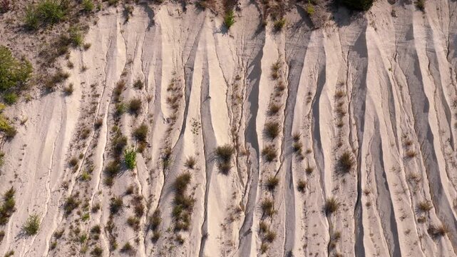 Aerial drone view of Arid landscape showing deep gullies and ravines forming on a steep white clay slope. Fetesti, Moldova