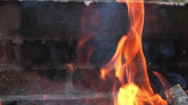 Cinematic slow motion of combustion, traditional campfire, outdoor cooking and camping, warmth, natural fuel and the elemental transformation of wood into fire