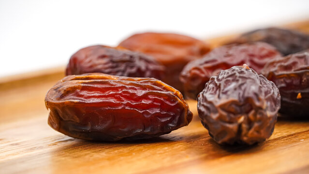 Close-Up of Sweet Premium Dried Dates on an Elegant Wooden Tray