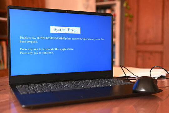 Technical Issues: A laptop displaying a system error message. The image shows a laptop with a blue error message on its screen. The study is faintly visible in the background.