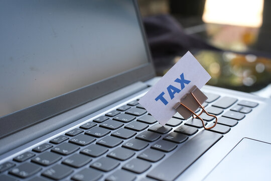 "TAX" text above the keyboard. Tax payment reminder concept.