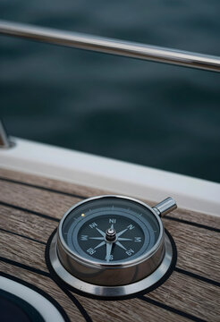 Navigation and direction concept, magnetic compass on a wooden boat deck for travel planning, maritime exploration and adventure journey at sea