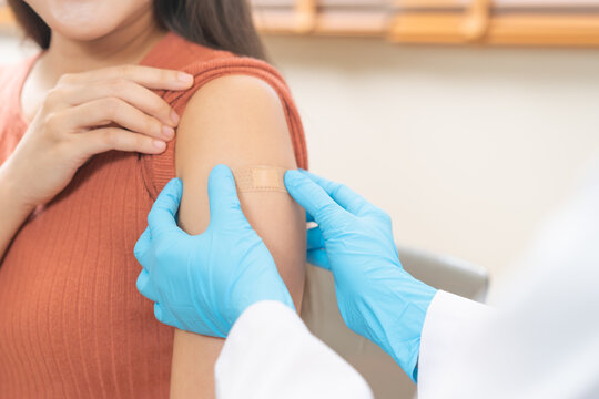 Vaccination coronavirus, hand of doctor apply plaster, bandage after doctor giving vaccine, injection dose on arm patient, immunization disease prevention against flu pandemic influenza, health care.