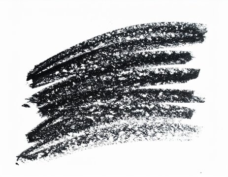 A black scribble mark with a rough texture, resembling a crayon or charcoal stroke on a white background
