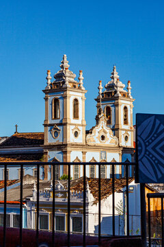 Historic colonial church with twin bell towers seen behind a railing in Salvador da Bahia, Brazil