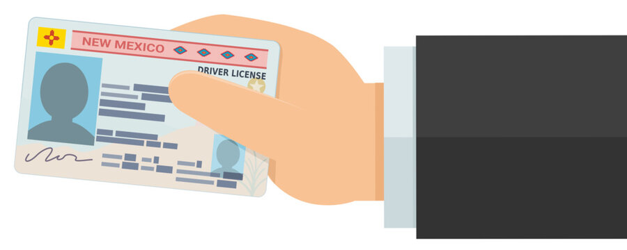 Hand presenting an official New Mexico Real ID driver license, symbolizing personal authentication, legal credential verification, and identity compliance. (cut out)