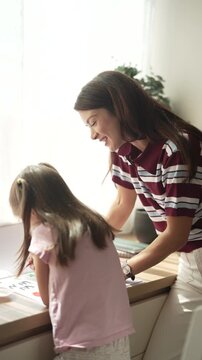 Mother helping daughter with homework at home